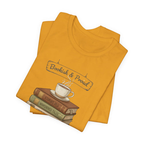 Folded mustard yellow t-shirt with 'Bookish & Proud' sign, books, and teacup.
