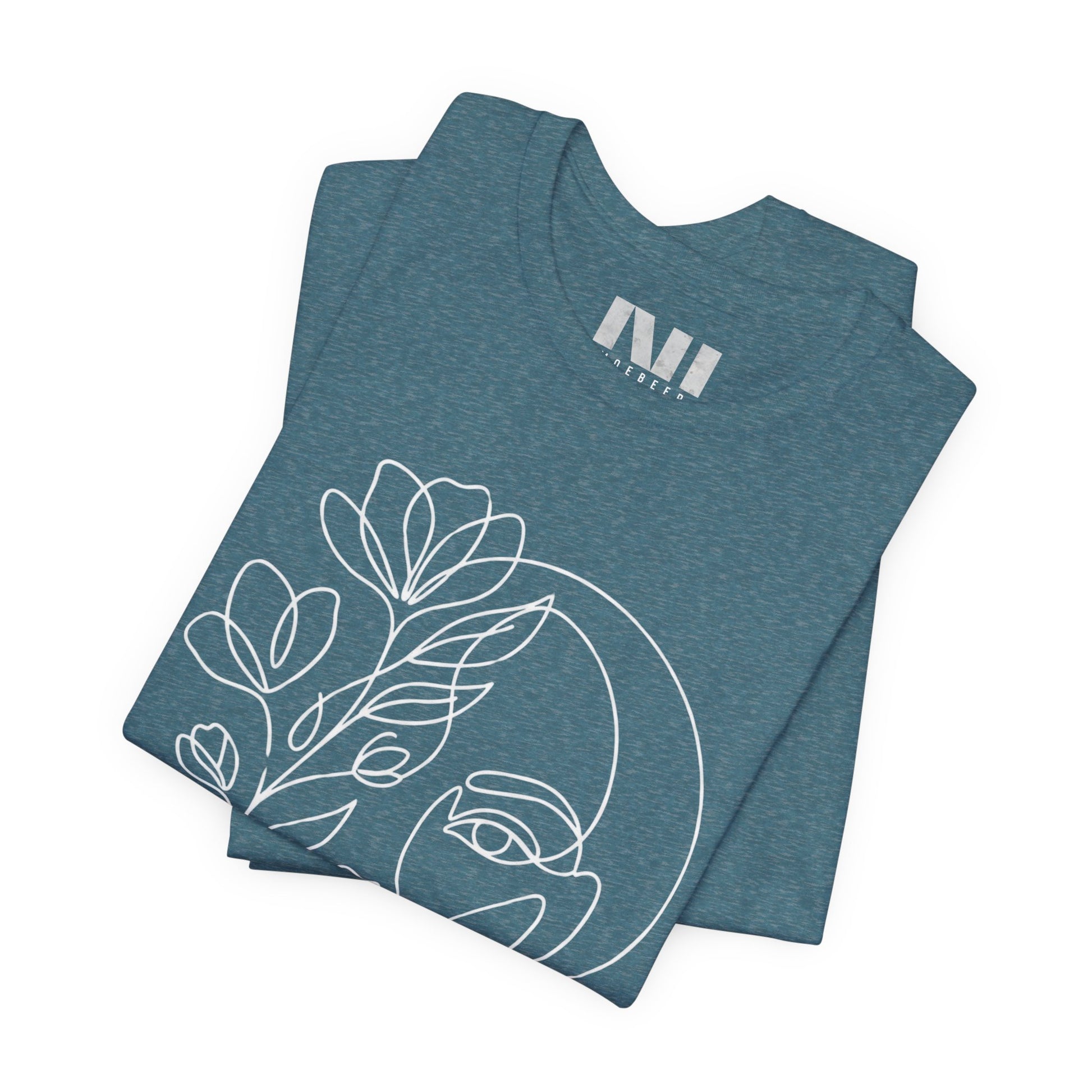 Folded Heathered Deep Teal graphic t-shirt featuring a minimalist black continuous line art design of a woman's face blooming with floral botanical elements. MOEBEER tees #Heather Deep Teal