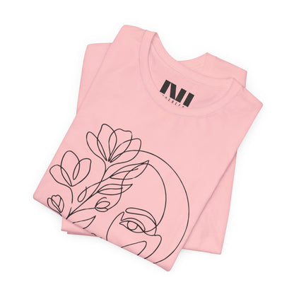 Folded Pink graphic t-shirt featuring a minimalist black continuous line art design of a woman's face blooming with floral botanical elements. MOEBEER tees #Pink