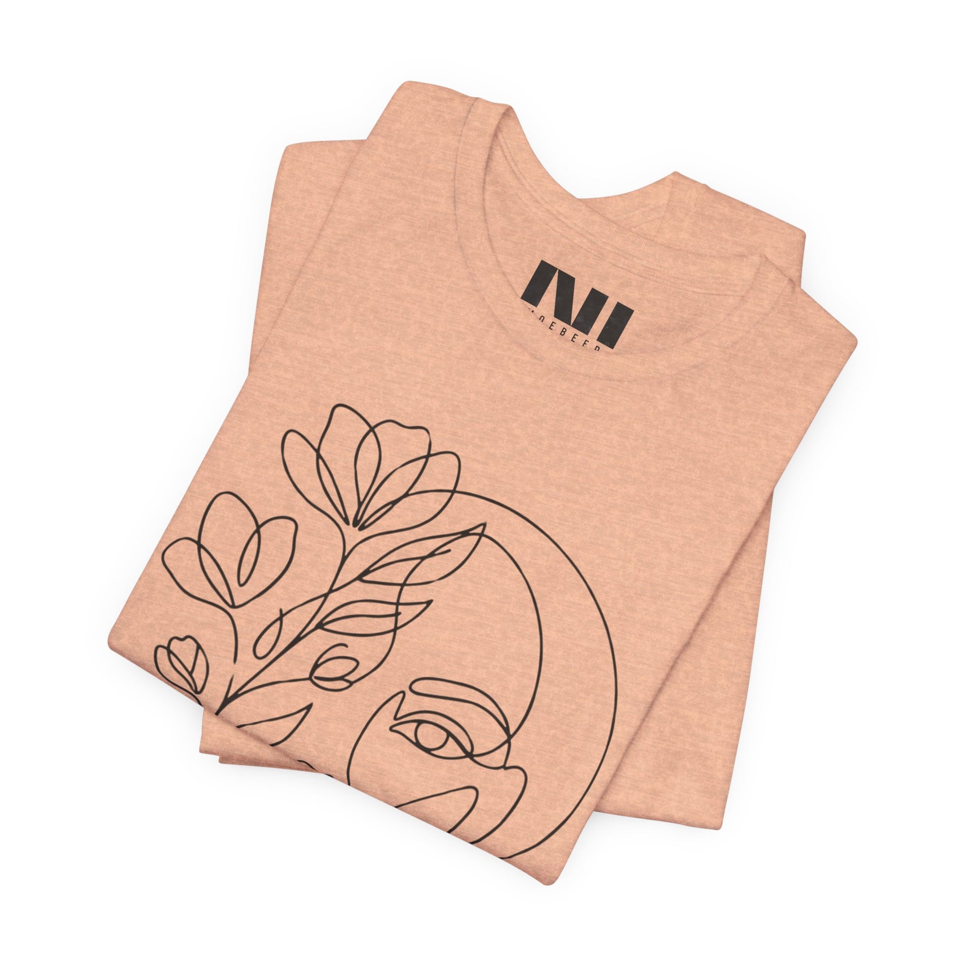 Heather Peach graphic t-shirt featuring a minimalist black continuous line art design of a woman's face blooming with floral botanical elements. #Heather Peach