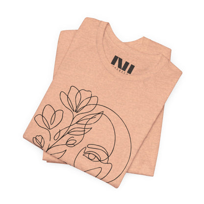 Heather Peach graphic t-shirt featuring a minimalist black continuous line art design of a woman's face blooming with floral botanical elements. #Heather Peach
