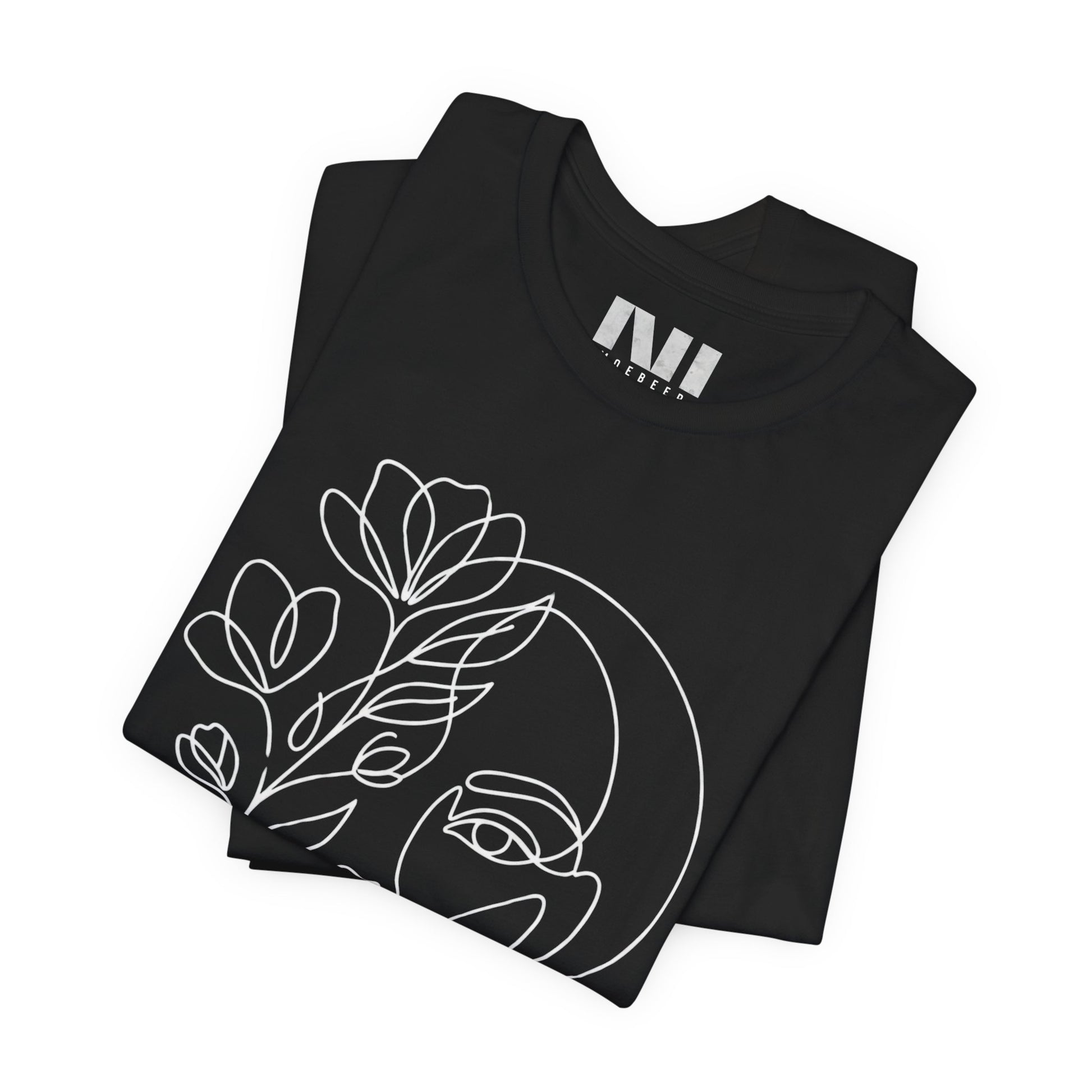 Folded Black graphic t-shirt featuring a minimalist black continuous line art design of a woman's face blooming with floral botanical elements. MOEBEER tees #Black