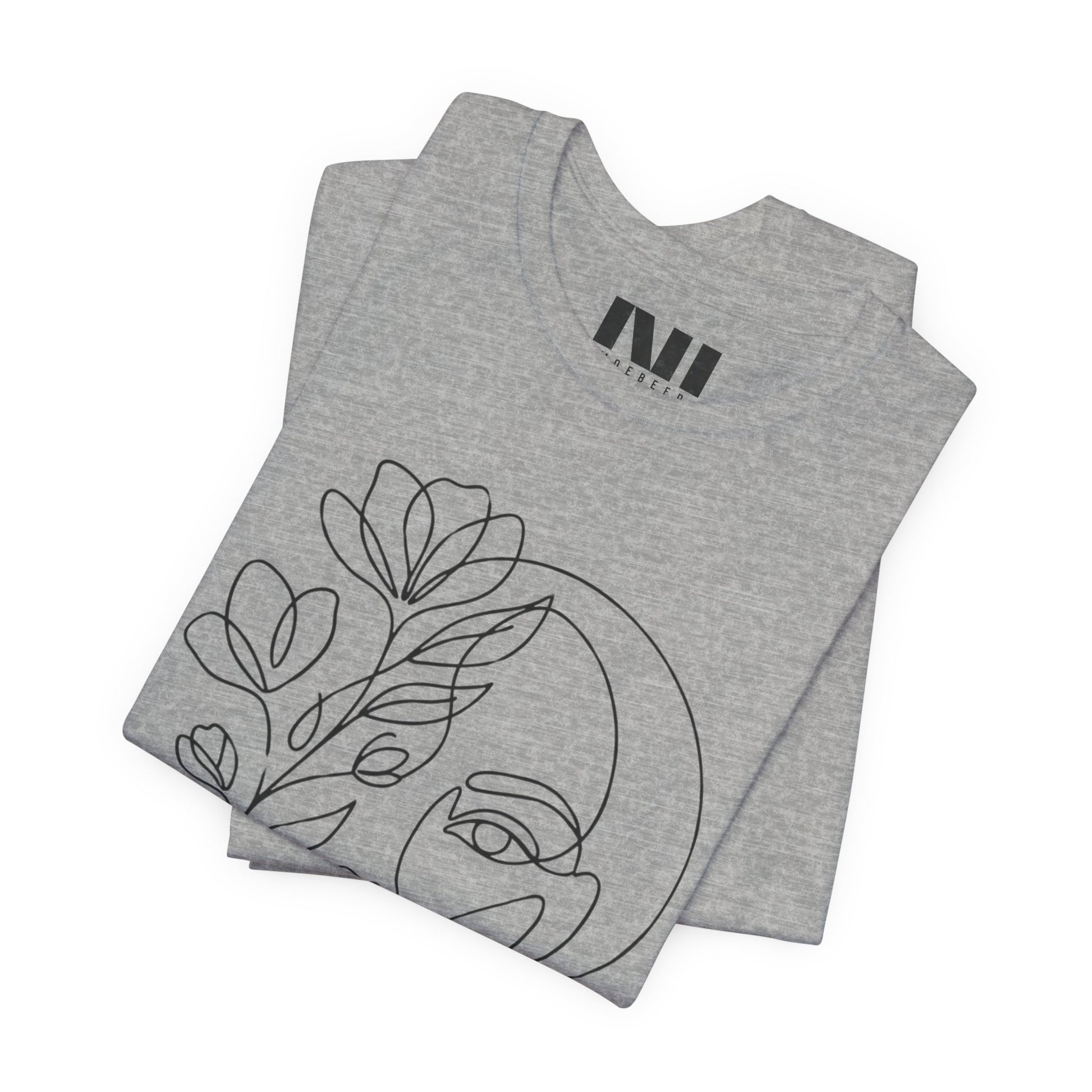 Folded Grey Heathered graphic t-shirt featuring a minimalist black continuous line art design of a woman's face blooming with floral botanical elements. MOEBEER tees #Athletic Heather