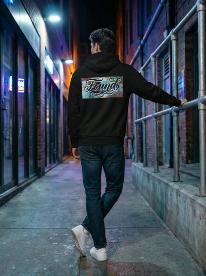 Person wearing  MOEBEER Hoodie featuring "Found" script over a colorful abstract paint design #Black