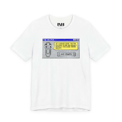 White t-shirt featuring a retro pixelated computer pop-up window graphic with a cartoon paperclip assistant. The text within the window reads, "IT LOOKS LIKE YOU'RE TRYING TO BE AN ADULT. WOULD YOU LIKE SOME HELP?" followed by a button that says "[ GO AWAY ]" #White