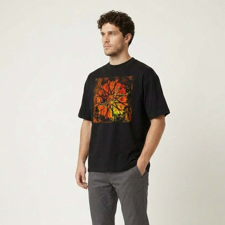Man wearing a black t-shirt with a colorful design and gray pants on a white background #Black