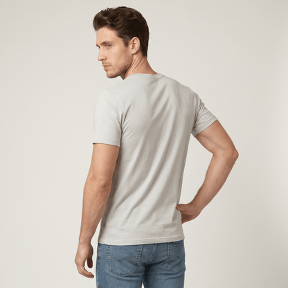 Man wearing a light gray t-shirt and blue jeans against a plain background #Silver