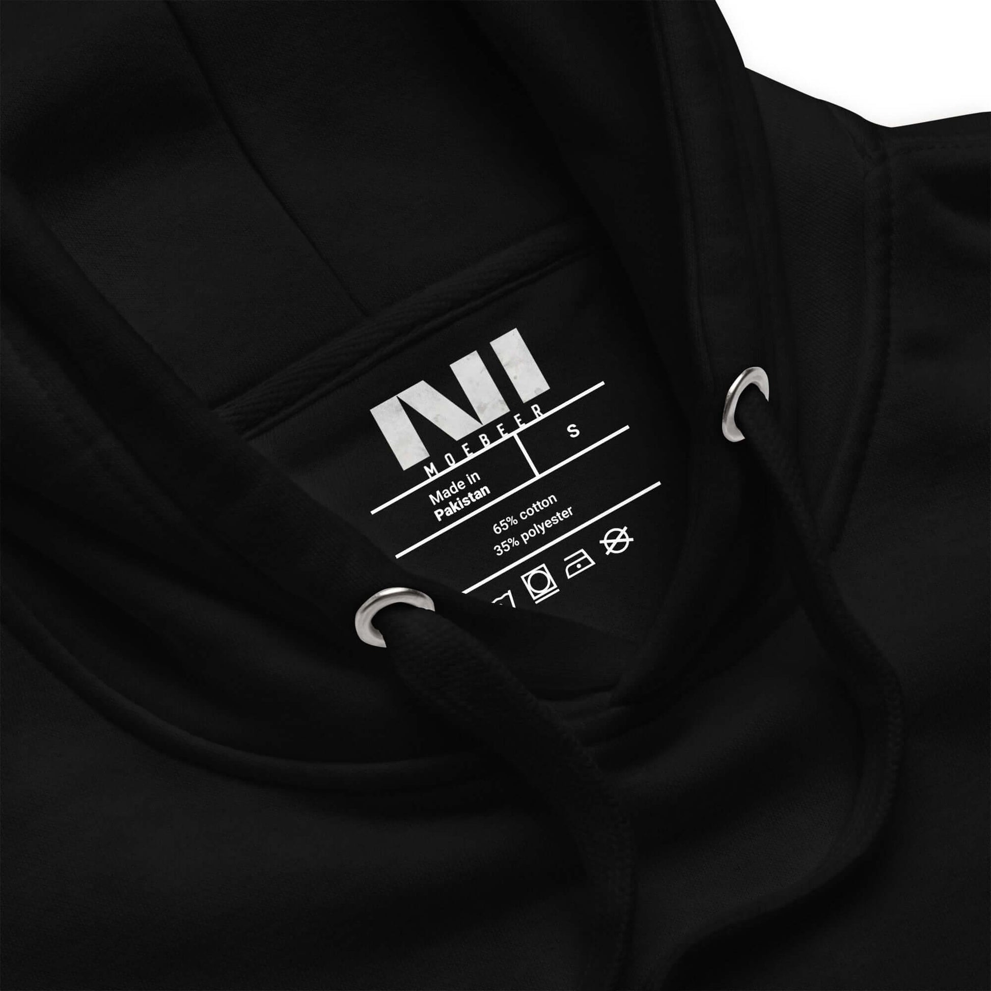 Inside label of a black Arabic calligraphy hoodie made in Pakistan with size details and care instructions. #Black